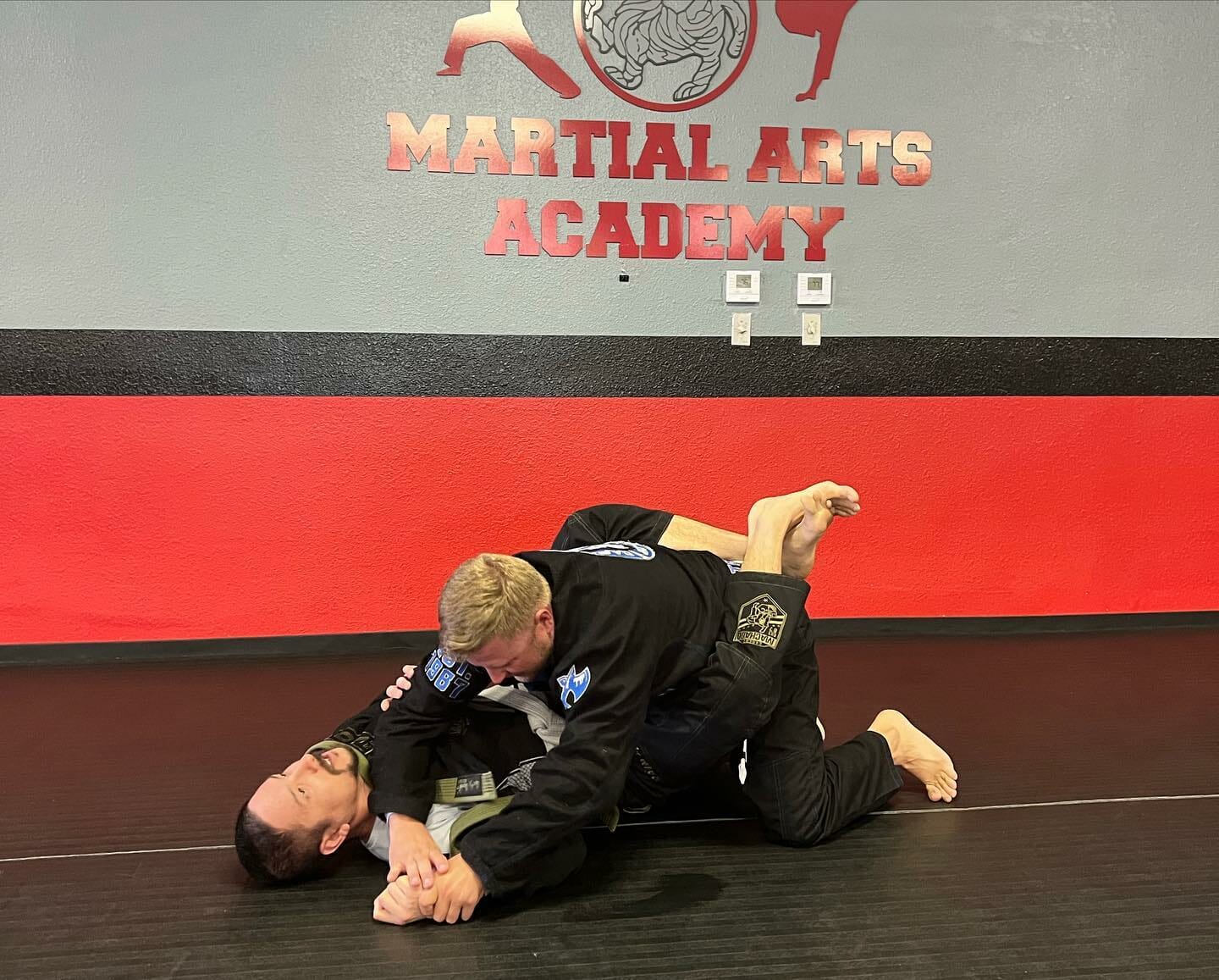 Adult Brazilian Jiu-Jitsu students rolling in gis