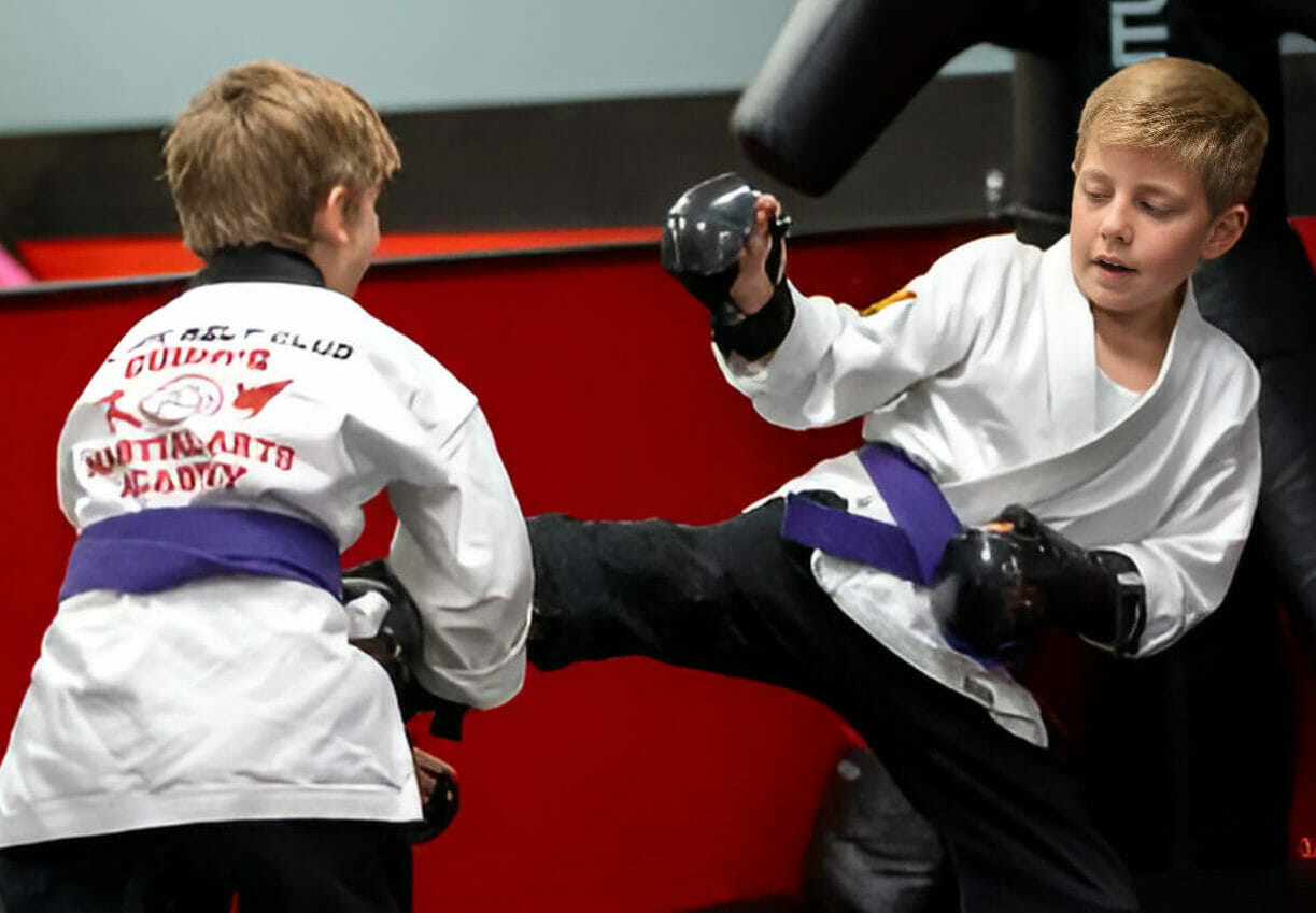 Juniors MMA student in striking stance with pads and gear